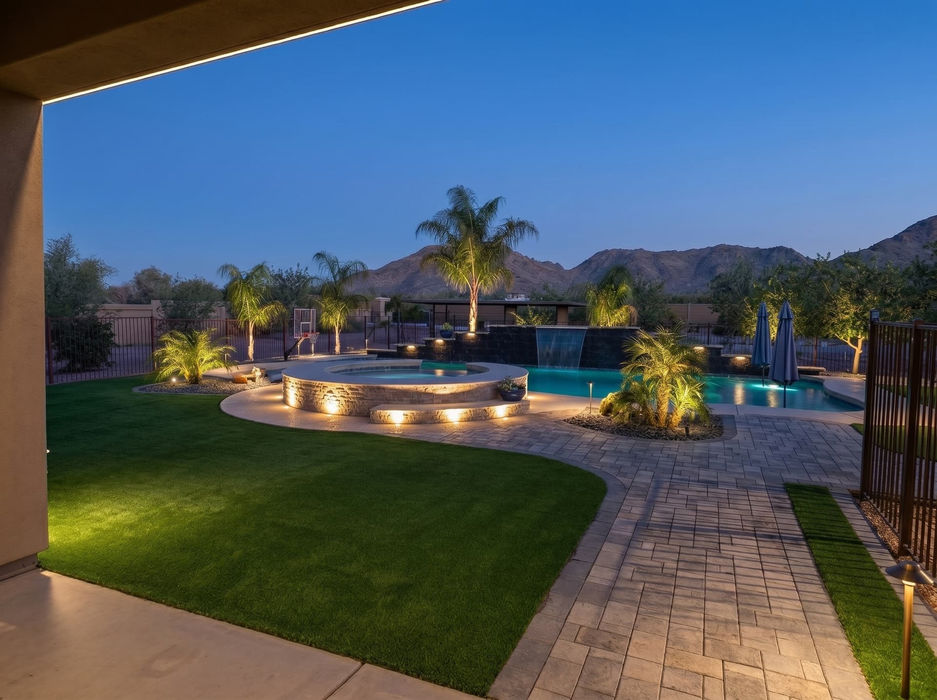 Paver walkway and turf around a pool, installed by AMW Hardscape Solutions